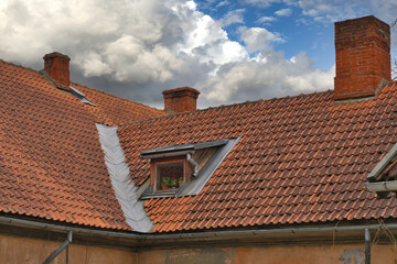 Obraz premium Red tiled roof of a residential building with a dormer window.