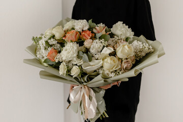 Large, delicate, spring bouquet of flowers on a white wall. Place for text. girl with flowers