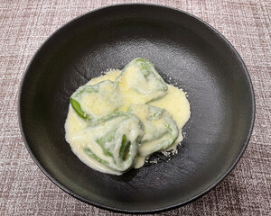 Italian Bolognesi Balanzoni. Green pasta with Parmigiano Reggiano cheese cream, filled with ricotta, mortadella and spinach.