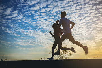 Silhouette of young woman start running at road track. Fit runner fitness runner during outdoor...