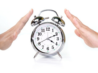 Retro alarm clock placed in the middle of a female hands making a stop gesture on white background.