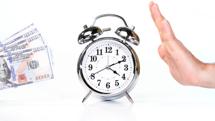 Retro alarm clock placed in the middle of a female hand and dollar cash on white background.