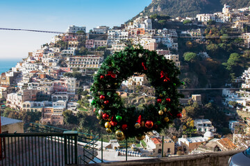 Christmas wreath with panoramic view on colorful houses of coastal town Positano, Amalfi Coast,...