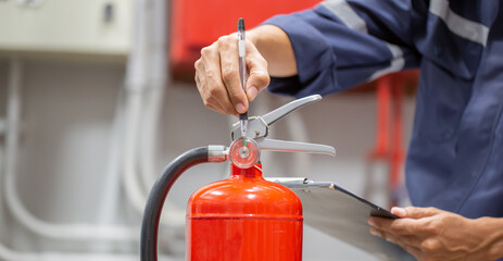 Engineer are checking and inspection a fire extinguishers tank in the fire control room for safety training and fire prevention.