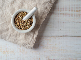 Hemp seeds in the bowl on wooden background.