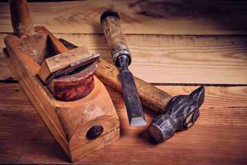 Set of carpentry tools hammer, chisel and plane on a wooden background.