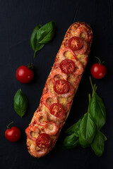 Homemade baguette sandwich or pizza with shrimp, cherry tomatoes  on top.