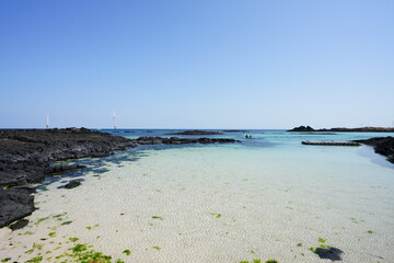 clear shoaling beach and turbines on the sea