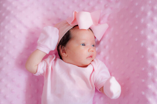 Newborn baby lay on pink blanket, beautiful photo of little girl 14 days, Two week old