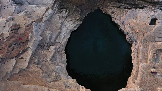 Flying above Mediterranean rocky coastline. Aerial view of  a natural seaside lagoon, pool. Giola, Thassos island, Greece