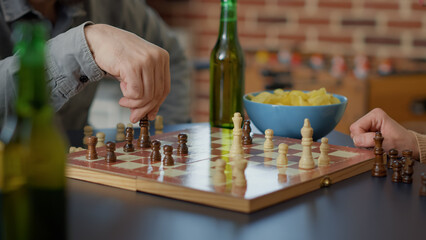 Young people having fun with chess board games play, serving alcoholic drinks and snacks. Group of...
