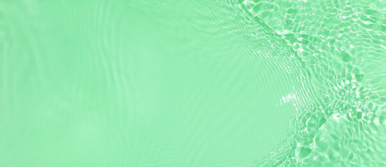 Abstract summer banner background Transparent green clear water surface texture with ripples and...