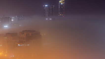 Buildings are covered in thick layer of fog in Business Bay night timelapse.