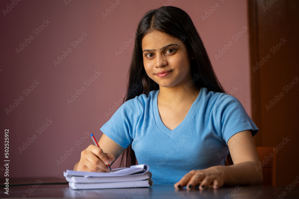 Wall mural Young Indian girl studying, making notes