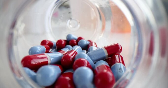 Scattered medical pills from jar on table