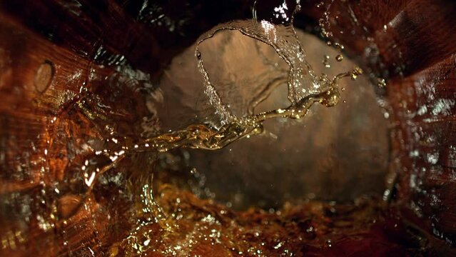 Super Slow Motion Shot of Splashing Whiskey in Old Oak Barrel at 1000fps.