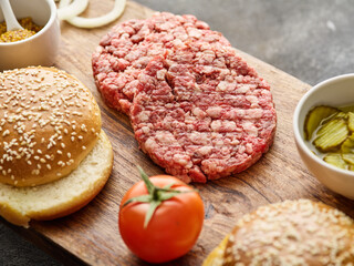 The raw ingredients for the homemade burger. Burger patties. Raw mince meat cutlet, ground beef and...