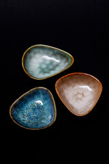 Small ceramic plates on a black background.