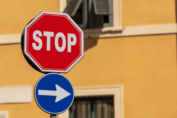 Close-up of an one way and a stop road sign with a residential building in the background, Brescia,...