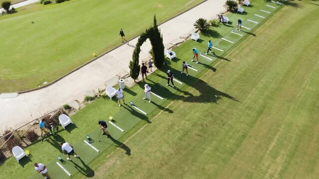 Aerial view of a row of people training on the golf course. Practice the swing