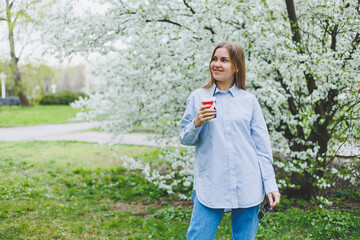 Fototapeta premium Portrait of attractive cheery dreamy girl drinking hot latte beverage resting strolling pastime on fresh air outdoors