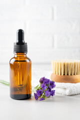 Spa set for skin care. Bottle of aromatic lavender essential oil and wooden brush with natural bristle for dry massage. Healthy skin, Unbranded package.