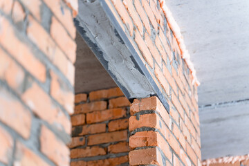 Mortgages for a door during the construction of a wall. A doorway in a brick wall from two iron...