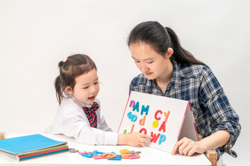 Mother and little girl are learning English letters