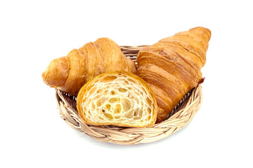 Plain Croissants and cut in half, showing the cross section in a wicker basket, a classic crescent-shaped croissant. isolated on a white background.