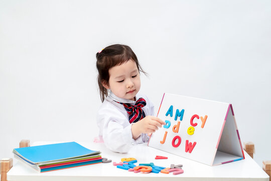 The lovely little girl is learning letters