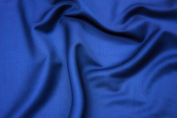 Fototapeta na wymiar Close-up texture of natural blue fabric or cloth in same color. Fabric texture of natural cotton, silk or wool, or linen textile material. Blue canvas background.