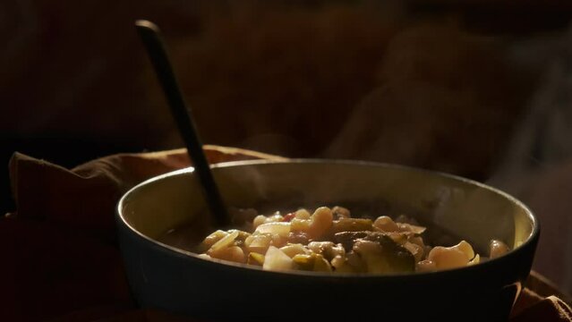 Bowl of vegetable soup with steam in a clair obscur slow motion 50p 4K