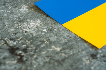 Ukraine national flag on gray concrete cement surface background. Place for text. War in Ukraine