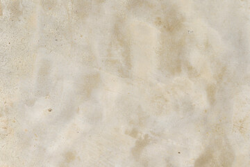The wallpaper on the old cement floor has water stains.