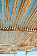 Fototapeta na wymiar Wooden structure providing shade in a sunny environment of Atacama Desert, Chile with a clear blue sky. Creating a natural, abstract pattern and texture. 