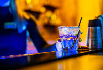 Woman bartender making cold gin tonic cocktail in bar