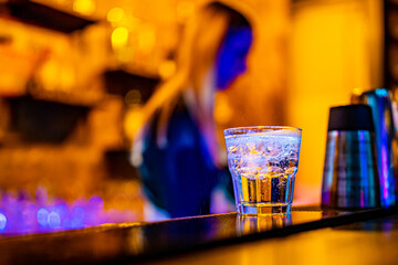 Woman bartender making cold gin tonic cocktail in bar
