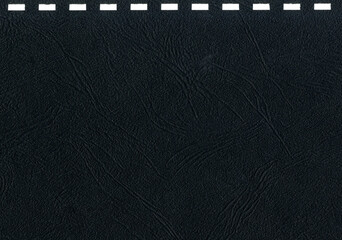 High resolution dark gray, black uncoated paper texture scan with square holes for notebook cover spiral binding string pattern office notebook cover with copy space for text