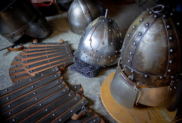 Historical background. Objects of medieval armor on a table covered with ancient fabric.