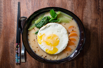 Japanese Ramen with sunny side egg topping with isolated wooden table background