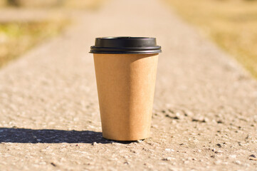 A close-up of a brown cardboard disposable coffee cup. A place for your packaging design.