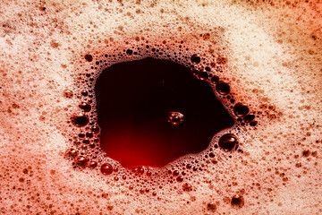 Dark red image of foam on liquid surface. Abstract red foam background.