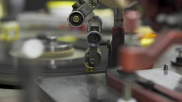 A large carat rough diamond is cut and shaped on a spinning grinding disk in the workshop of a skilled diamond cutter.