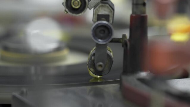 A large precious diamond gem is cut and shaped on a spinning diamond cutter's shaping wheel at a jeweler.
