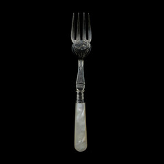 engraved antique silver fork. vintage cutlery for table setting on black isolated background