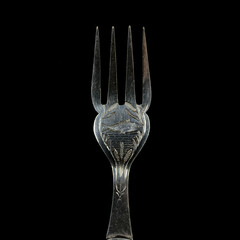 engraved antique silver fork. vintage cutlery for table setting on black isolated background