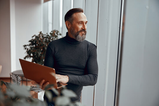 Happy Man Looking Out The Window While Holding Laptop, Copy Space