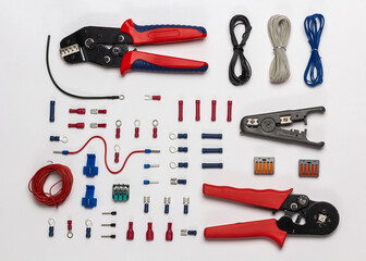 Top view of electrical tools and terminal lugs on white background