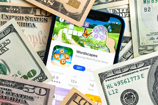 Wordscapes mobile game app. Money background. Concept, company making money with popular mobile phone games