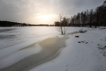 Spring landscape with a river. Snow melts in March. Evening in early spring.